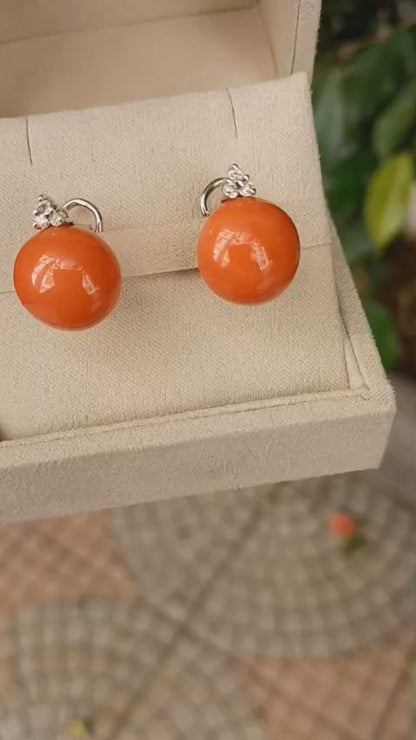 Orecchini in oro bianco 18 kt. con bottoni di corallo del Pacifico e diamanti